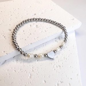 Detail of silver bead elastic bracelet with freshwater pearls and a heart pendant