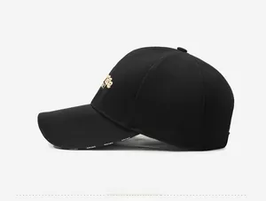 Detail of black baseball cap with SPORT lettering and gold embroidery on breathable fabric