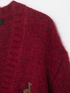 Detailed macro view of burgundy mohair knit cardigan with gold giraffe bead embroidery