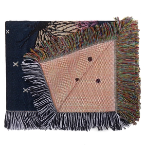 Detail of bohemian jacquard woven blanket showing fringe edges and complex texture
