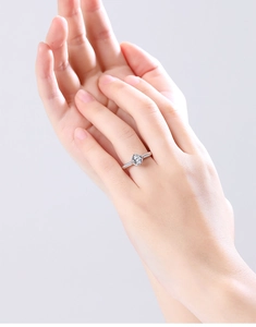 Detailed close-up of a S925 sterling silver six-prong moissanite ring on a finger