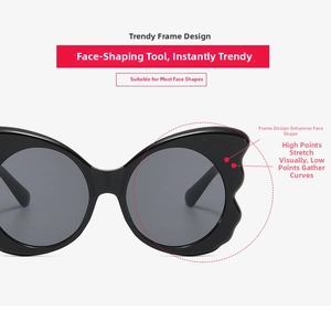 Detail of butterfly-shaped sunglasses showing the curved black frame and dark grey lenses
