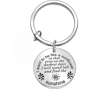 Macro view of sunflower keychain with engraved inspirational quote on round metal tag