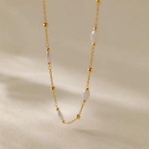 Elegante collana a catena dorata con perle d'oro e perle bianche ovali alternate