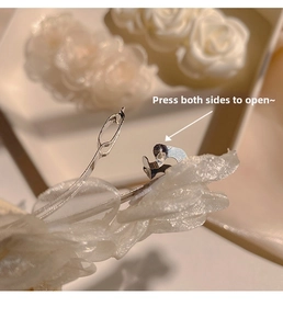 Macro detail of white lace camellia hair clip showing metal spring buckle mechanism