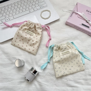 Floral corduroy drawstring cosmetic pouches in pink and blue for travel storage