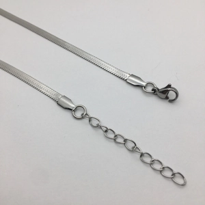 Macro shot of silver flat snake chain featuring lobster clasp and extension link