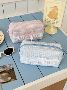 Detailed heart-shaped quilting with delicate lace trim and silk bow on a cosmetic bag
