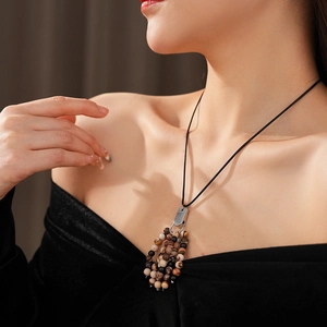 Close-up of vintage beaded natural stone pendant necklace worn by a fashion model