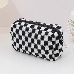 Detailed view of checkered knit makeup bag with black zipper and woven texture