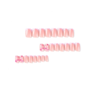 Pink French tip press on nails with heart patterns and glossy finish on white background