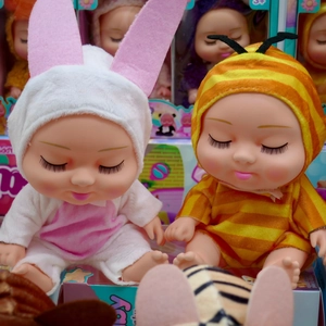 Close-up of cute sleeping 8-inch BJD dolls in rabbit and bee themed plush outfits