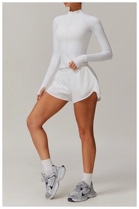 Detail view of white long sleeve zip-up workout top with functional thumbhole cuffs