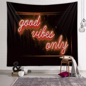Detail of neon red 'good vibes only' wall tapestry on a white brick background