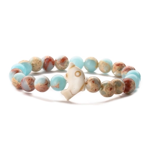 Detail of colorful turquoise beads and tiger eye stone bracelet with a white dolphin charm