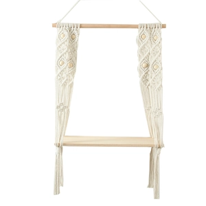 Close-up of bohemian hand-woven cotton rope tassels and wooden beads on wall shelf