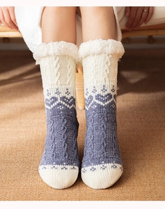Close-up of blue and white knitted floor socks with geometric patterns and fuzzy cuffs