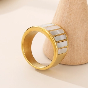 Minimalist wide gold titanium ring with white shell inlay on a wooden cone stand