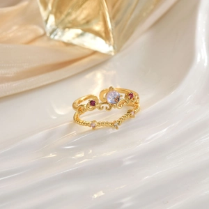 Luxury crown ring with rainbow gemstone and red stones on elegant silk fabric background