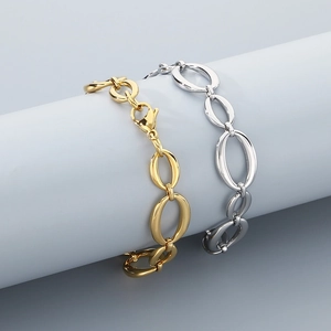 Detail of gold and silver polished oval link bracelets with lobster clasp on a white stand