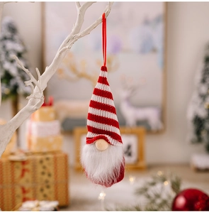 Detail of a red and white striped gnome ornament hanging on a festive Christmas tree