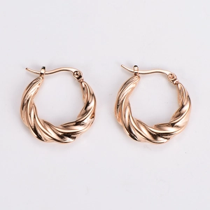 Close-up of rose gold twisted hoop earrings with a polished metallic woven texture