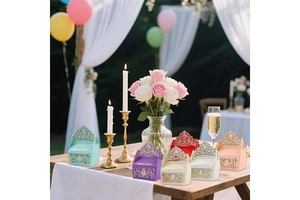 Detail of laser-cut crown paper candy boxes in multiple colors for wedding table decor