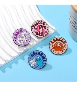 Detailed close-up of colorful round enamel zodiac pins on a white wave display stand