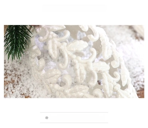 Close-up of white glitter Christmas tree leaf ornament with sparkling hollow pattern