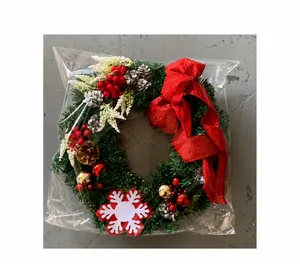 Detail of Christmas wreath packaging with Merry Christmas sign, red bow and pine cones