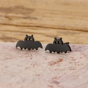 Vue macro de boucles d'oreilles chauve-souris noires en acier sur base de pierre