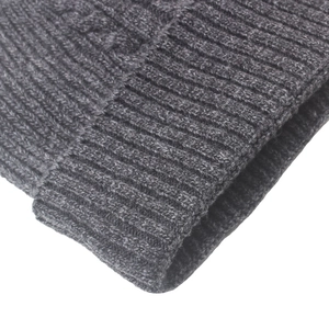 Detail view of dark grey knitted wool beanie showing ribbed and cable stitch texture