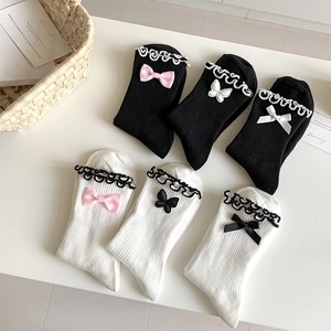 Flat lay of six pairs of JK style ruffled socks with bowknot accents in black and white