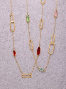 Detail of long gold necklace with hammered oval links and colorful Czech glass stones