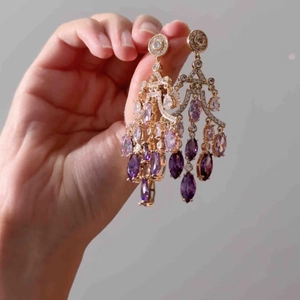 Elegant 18K gold plated drop earrings with purple zircon tassels held by hand