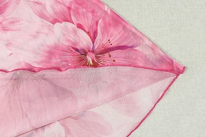 Vue macro de l'imprimé floral rose avec texture en mesh et détails de l'ourlet fini