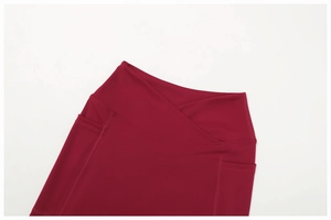 Détail de la taille croisée en V et de la poche latérale sur le legging de yoga bordeaux