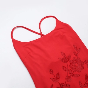 Detailed close-up of vibrant red dress featuring intricate floral bead embroidery and sequins