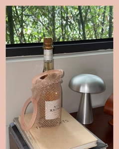 Detailed view of pink mesh wine bag with sparkling rhinestones and round handles