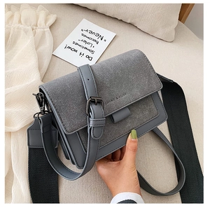 Detail of grey retro satchel bag featuring matte texture and wide woven shoulder strap