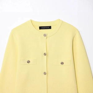 Women's yellow knit cardigan featuring a round neck and gold buttons on white background