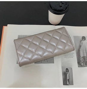 Champagne gold quilted leather long wallet placed on a magazine with coffee background