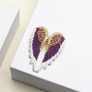 Elegant angel wing brooch with purple and white enamel and sparkling rhinestones