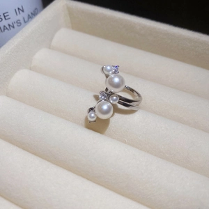 Detailed macro view of silver ring with white pearls and sparkling cubic zirconia stones