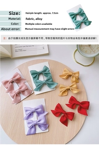 Close-up of 7.5cm satin bow hair clips in five vibrant colors on a wooden tray