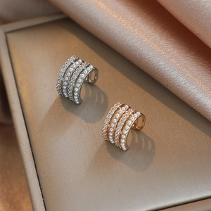Macro shot of gold and silver layered ear cuffs with inlaid pearls and zircon stones
