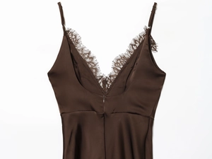 Détail d'un caraco en satin marron avec dentelle délicate et fines bretelles réglables