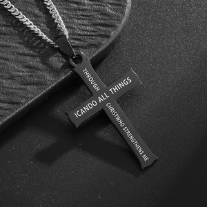 Detailed macro view of matte black cross pendant with engraved Bible verse on link chain