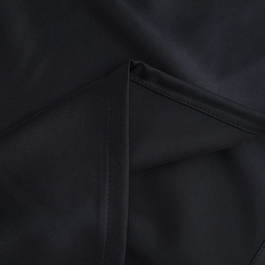 Close-up of black satin fabric texture and high-quality stitching on a sleeveless dress
