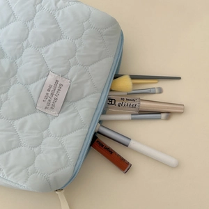 Macro view of blue heart quilted makeup bag showing spacious interior and brush slots